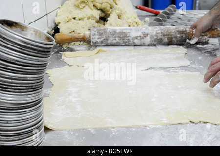 Panificio industriale. Baker e per impastare la pasta di appiattimento Foto Stock