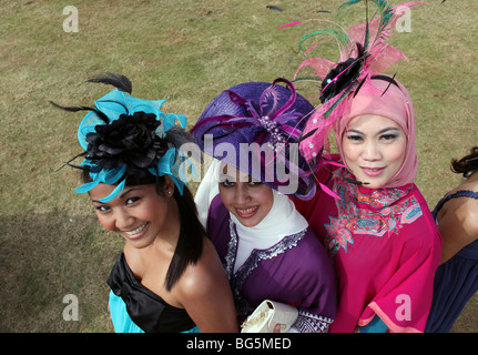 Elegantemente vestito donne indossare cappelli durante una corsa di cavalli, Dubai, Emirati Arabi Uniti Foto Stock