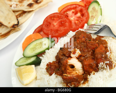 Un piatto di pollo tikka masala, servito con riso bianco, un lato di insalate e piatti o chapatti pane naan. Foto Stock