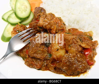 Una piastra di tradizionale di montone vindaloo, servita con riso e insalata di cetrioli e carote. Foto Stock