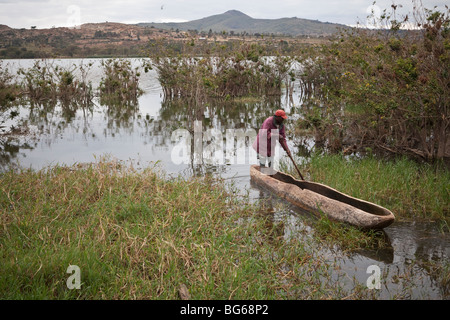 Un uomo righe attraverso le lamelle lungo le rive del lago Babati nel centro della Tanzania. Foto Stock