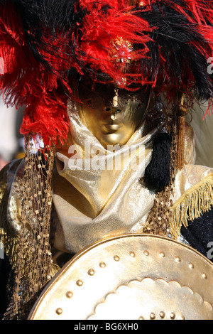 Close-up di un veneziano di uomo che indossa una maschera dorata e la protezione che rappresenta un guerriero in Carnevale di Venezia Foto Stock