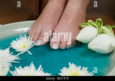 Piedi godersi un rilassante aromaterapia spa del piede con fiori di loto Foto Stock