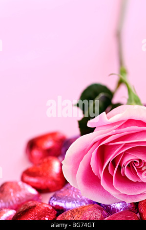 Rosa rosa con Valentine's Chocolates avvolto in rosso e viola foil Foto Stock