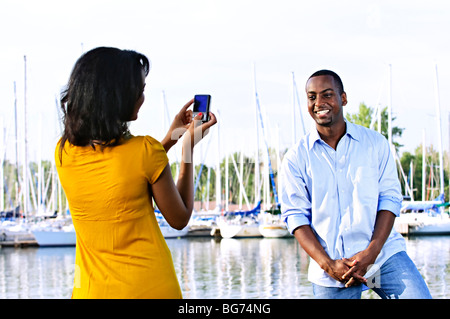 Uomo bello che posano per una foto di vacanza a porto con barche a vela Foto Stock