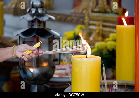 Donna bruciare bastoncini di incenso. Wat Chana Songkhram. Bangkok. Della Thailandia Foto Stock