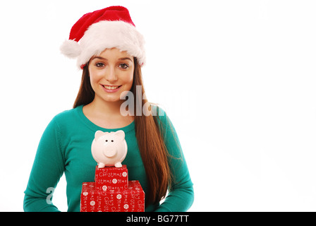 Giovane donna tenendo i regali di Natale e un maiale casella di denaro Foto Stock