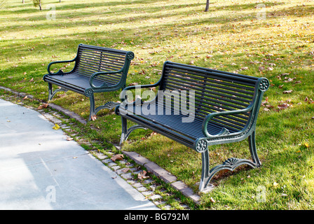 Due banchi di metallo nei parchi della città. Foto Stock