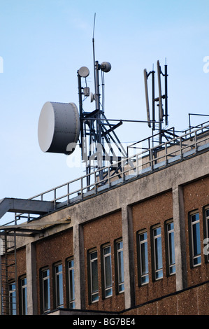 Antenna a microonde sulla parte superiore di un centralino telefonico accanto a Rete cellulare antenne. Foto Stock