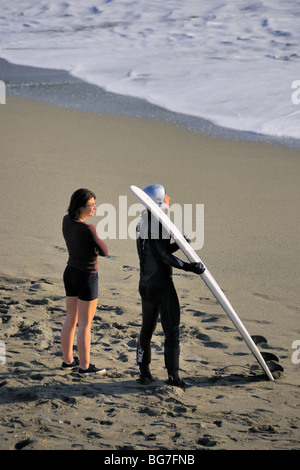 Un surfista è in attesa di una buona onda alla spiaggia di Levanto, Liguria, Italia. Foto Stock
