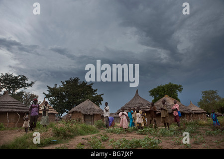 I residenti di stand al di fuori delle loro case di fango in Acowa Refugee Camp in Amuria District, Uganda, Africa orientale. Foto Stock