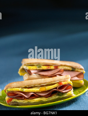 Prosciutto e uova panini colazione sulla piastra verde Foto Stock