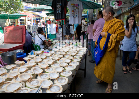 Monaco buddista e noci di cocco. Pressione di stallo di cibo. Bangkok. Della Thailandia Foto Stock