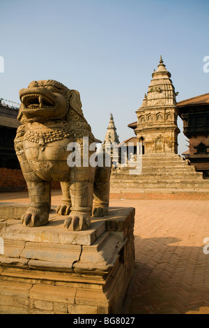 Un leone di pietra e Vatsala Tempio a Durbar Square a Bhaktapur, nella valle di Kathmandu in Nepal. Foto Stock