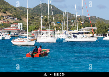 Barche presso la Clifton, union island, west indies - water taxi in direzione di yacht ormeggiati nella baia. Foto Stock