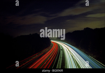 L'autostrada M11 in Essex,Gran Bretagna, di notte mostra auto di testa e di coda i sentieri della luce in condizioni di traffico intenso. Foto Stock