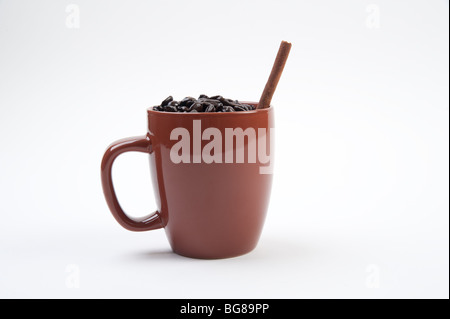 Tazza da caffè piena di chicchi di caffè su sfondo bianco Foto Stock