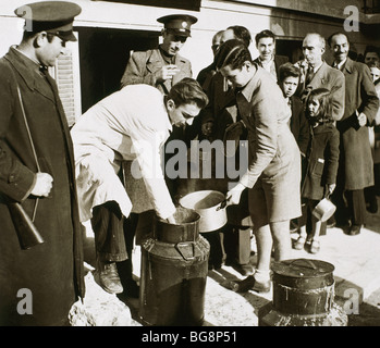 Seconda Guerra Mondiale (1939-1945). Gli alleati sparsi cibo tra la popolazione greca con razione della carta. Marzo 1940. Atene. La Grecia. Foto Stock