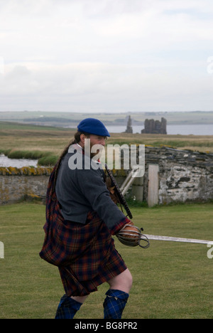 Un uomo in costume storico re-decreta battaglie storiche al Sinclair raccolta, Noss, vicino a Wick, Scozia. Foto Stock