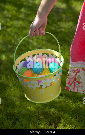 Ragazza con uovo di Pasqua nel carrello mentre si cammina sul prato Foto Stock