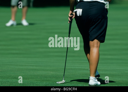 Giocatore di golf femminile appoggiata al suo golf club Foto Stock