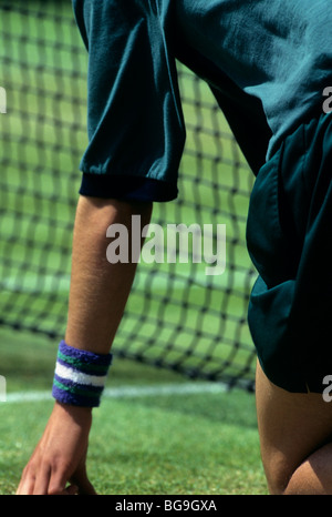 Wimbledon palla ragazzo in ginocchio dalla rete Foto Stock