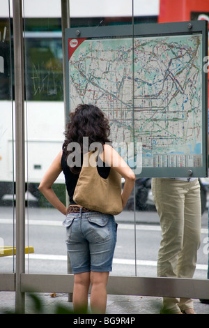 TURISTA, CONTROLLANDO LA CARTINA, BARCELLONA: In un mondo prima dei telefoni cellulari un turista perduto guarda una mappa della fermata dell'autobus della metropolitana della città di Barcellona Spagna 2007 Foto Stock