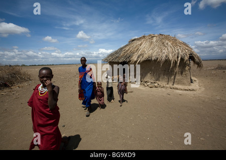 Una famiglia Masai esce dalla loro casa nel villaggio di Tindagani, regione di Kilimanjaro, Tanzania Africa Orientale. Foto Stock