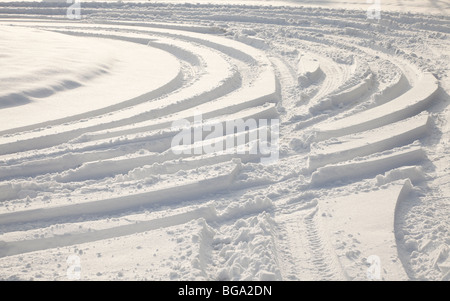 Pneumatico auto tracce nella neve profonda, sole invernale Foto Stock