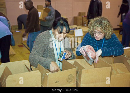 Gli studenti delle scuole superiori e gli insegnanti pack cibo per i bisognosi Foto Stock