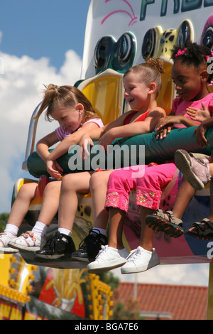 Tre ragazze alla tramoggia di rana Carnival Ride. Ohio State Fair. Columbus, Ohio, Stati Uniti d'America. E caucasici Afroamerican ragazze. Foto Stock