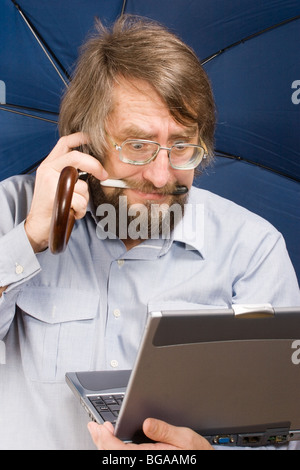 Imprenditore con molto sorpreso di fronte a vetri con il notebook, telefono cellulare, ombrello nelle sue mani e penna in i suoi denti Foto Stock