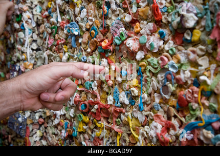 Mano d'uomo puntando verso il famoso muro di gomma, del Mercato di Pike Place, Seattle Washington Foto Stock