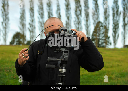 Fotografo di paesaggio Tony Wainwright con una telecamera panoramica 6x17 su treppiede che lavora nei campi del Sussex orientale. Foto Stock