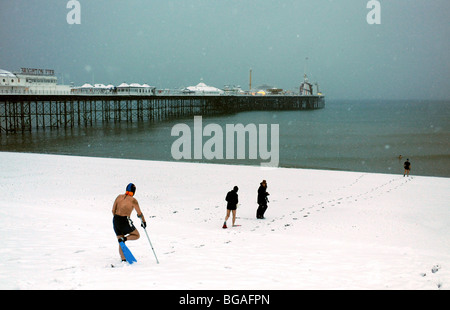 I membri del Brighton Swimming Club si dirigono lungo la spiaggia per la loro nuotata quotidiana nonostante le forti nevicate e le condizioni di congelamento - Febbraio 2009 Foto Stock