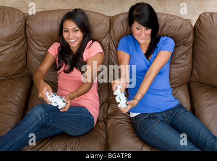 Due giovani giocare in modo aggressivo un video gioco a casa. Foto Stock