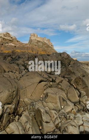 Lindisfarne Castle, Isola Santa, Northumberland, Regno Unito. Maggio. Vista da rocce sulla riva. Foto Stock