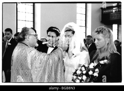 La religione Cristiana Greco tradizionale matrimonio. Sacerdote sposa offerta di vino durante la cerimonia. Foto Stock