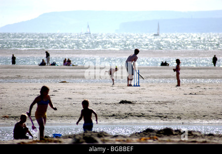 Royalty free fotografia di famiglie giocando su British spiaggia costiera in estate a bassa marea UK. Foto Stock