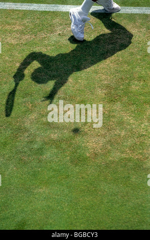 Giocatore di tennis e di ombra su una corte di erba Foto Stock