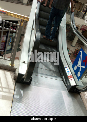 Persone che viaggiano fino escalator in centro commerciale Foto Stock