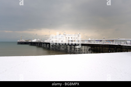 Al molo di Brighton e spiaggia coperta di neve Foto Stock