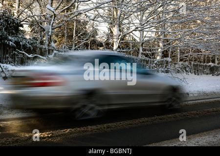 Auto velocizzando il passato su gelido inverno road Foto Stock