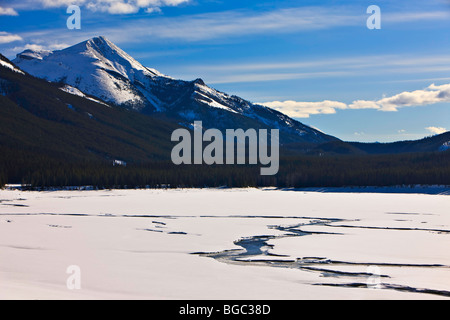 Cannels attraverso il ghiaccio e la neve sulla medicina lago, il Lago Maligne Road, Jasper National Park, Canadian Rocky Mountains, Alberta, C Foto Stock