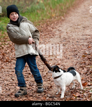 Un ragazzo, 7 anni, giocando con il suo cane Foto Stock