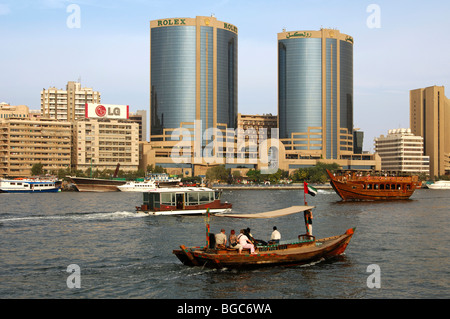 Il traffico delle barche con a bordo di un giunco e abras sul torrente di fronte alle Torri Gemelle a Dubai, Emirati Arabi Uniti, Medio Oriente Foto Stock