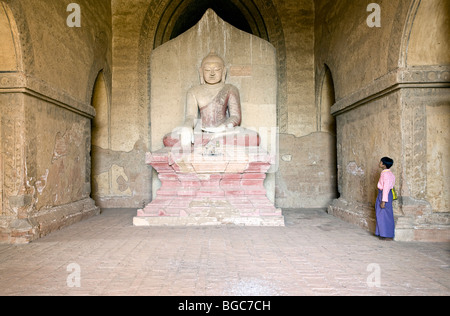 Ragazzo birmano contemplando una statua di Buddha. Dhammayangyi Tempio. Bagan. Myanmar Foto Stock