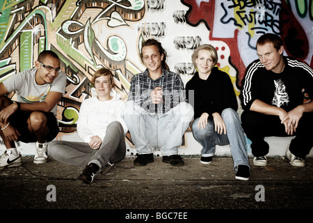 Un gruppo di giovani di fronte a un muro di graffiti, gioventù, gruppo, fresco Foto Stock