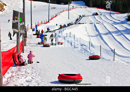 La gente camminare fino al magico tappeto sollevare con i tubi in corrispondenza del tubo di Coca-Cola Park sul Monte Blackcomb, Whistler Blackcomb Foto Stock