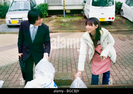Giovane uomo e donna saluto ogni altro a drop off site Foto Stock